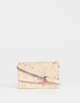 Bandolera color crema con estampado floral en tonos rosa y lila. Tiene solapa con cierre de botón a presión y correa de cadena metálica plateada.