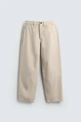 Pantalón chino color beige, de corte relaxed fit, confeccionado en tejido de mezcla de algodón y lino. Cuenta con bolsillos delanteros y traseros de vivo. Cierre frontal con cremallera y botón.