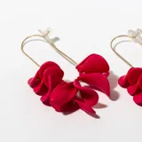 Aros colgantes con forma de gota, color fucsia, con estructura dorada.