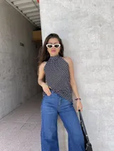 Top negro con lunares blancos, cuello halter y espalda descubierta.