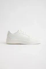 Zapatillas urbanas blancas de cuero sintético con cordones y suela plana.