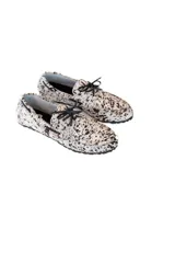 Mocasines con capellada de cuero con estampado animal print en tonos blanco y marrón. Presentan cordones de cuero negro y suela plana.
