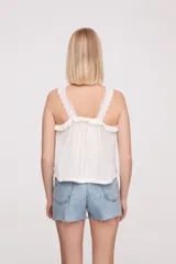 Musculosa color salmón con breteles finos y detalle de puntilla en el escote.