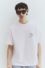 Remera blanca de algodón con cuello redondo y hombros caídos. Estampado pequeño en el pecho con la frase "Puerto Vallarta Beach Bar". Corte holgado.