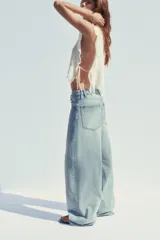 Pantalón de jean celeste de tiro alto con cintura doblada, cinco bolsillos, efecto lavado y roturas.