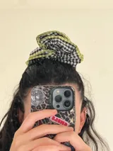 Coletero de pelo con estampado de cuadros blancos y negros, bordeado con una costura de color amarillo flúor.