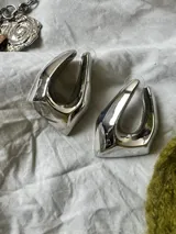 Aros plateados con forma irregular.