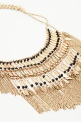 Collar dorado con flecos de cadenas y detalles de canutillos y mostacillas negras.