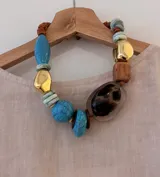 Collar corto con cuentas de diferentes materiales y colores: turquesa, dorado, marrón y transparente con estampado animal print.