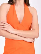 Vestido corto naranja con escote halter y espalda descubierta.
