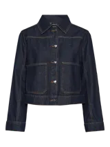 Chaqueta de denim azul oscuro con cuello camisero, cierre frontal con botones en forma de corazón, bolsillos delanteros y costuras en contraste color ocre.
