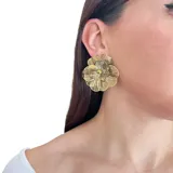 Aros colgantes con forma de flor metálica dorada.