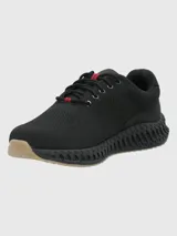 Zapatillas deportivas negras de tejido de punto con cordones negros con detalles rojos. Suela negra con textura y base color caramelo.