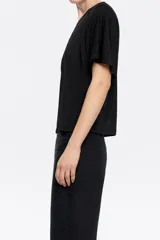 Camiseta negra fluida de corte boxy, con escote a la caja, manga corta y pliegues en el hombro.