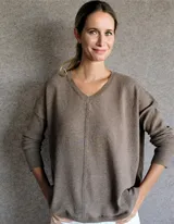 Buzo de lambswool color crema, con diseño holgado y manga larga, ideal para combinar con diferentes prendas.