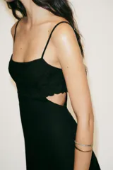 Vestido midi negro con tirantes finos, escote recto, aberturas laterales y bordados de flores.