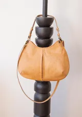 Cartera de cuero color beige con forro interior, cuenta con doble correa desmontable.