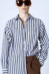Camisa celeste con rayas verticales blancas, de corte clásico y manga larga.