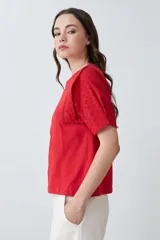 Remera roja de algodón con cuello redondo y mangas cortas con detalle de broderie. Corte clásico.