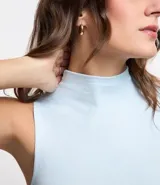 Blusa sin mangas en viscosa color blanco, con cuello alto y textura acanalada.