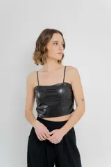 Top crop negro de cuero ecológico con tirantes finos y espalda de encaje floral con base nude.