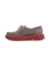 Zapato acordonado color gris con suela de goma color ladrillo.