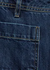Pantalón de jean azul oscuro, de corte wideleg, tiro alto y bolsillos de parche frontales.