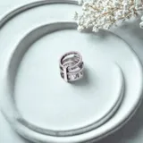 Anillo plateado de triple alianza con números romanos y circonitas.