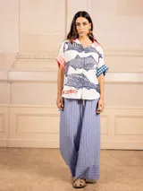 Pantalón palazzo con estampado de rayas verticales finas y detalle en el bajo. Tiene elástico en la cintura.