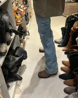 Bota alta de cuero vacuno color negro, con caña recta, punta cuadrada y estribo desmontable.