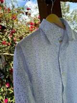 Camisa de manga larga con estampado de flores pequeñas en tonos celeste y blanco.