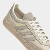 Championes Adidas Handball Spezial color beige con detalles en gris y suela de goma color caramelo. Presentan las tres tiras características de la marca en los laterales y la inscripción "Spezial" en letras doradas.