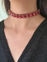Gargantilla choker color fucsia con cristales facetados ovalados engarzados en dorado y trenzado con tiento simil gamuza. Se cierra con cadena de acero quirúrgico y ganchito para ajustar.