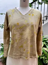Remera de manga larga color beige con cuello en V y estampado botánico.