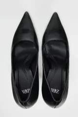 Zapato de tacón fino negro, con escote redondo y acabado en punta.