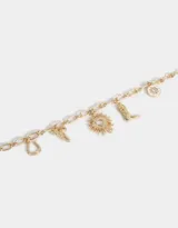 Pulsera dorada con cadena de eslabones y dijes colgantes: herradura, bota campera, sol con corazón, moño, y dije redondo blanco con strass.