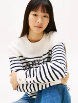 Sweater Tommy Jeans de algodón regenerativo a rayas horizontales blancas y azules, con cuello redondo y logo bordado en el pecho y en el puño.