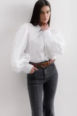 Camisa color beige de algodón con mangas abullonadas y cierre con botones.