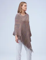 Poncho de tejido suave, color crudo con hilos multicolores que generan un efecto jaspeado en tonos pastel (rosa, celeste, lila). Presenta un diseño asimétrico con cuello redondo y terminación en flecos largos en el ruedo.