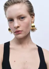 Top negro de tejido de punto fino con corte peplum, escote en V y tirantes anchos.