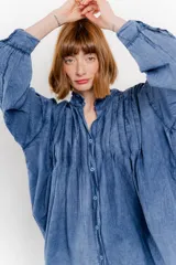 Camisa oversize blanca de algodón con pliegues frontales.