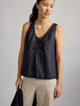 Top color rosa pálido de lino con cuello en V y bordado de un trébol de cuatro hojas en el centro.