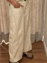 Pantalón ancho color beige, de corte holgado desde la cadera hasta el tobillo.