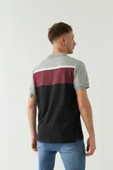 Remera cuello polo de manga corta con diseño en bloques de color gris, blanco, bordó y negro.