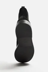 Bota Chelsea de cuero negro con elástico lateral, tirador trasero y suela con ligero tacón.