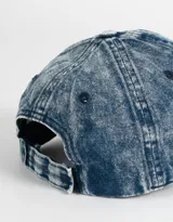 Gorra de denim celeste con efecto gastado, con bordado de corazón rojo y frase "Let's Grow Some" en blanco.