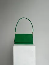 Cartera verde con textura símil piel de serpiente, para usar al hombro, con doble compartimiento interno, dije de marca metálico y cerramiento con broche imán.