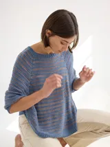 Buzo tipo poncho con mangas, tejido de punto color celeste con rayas horizontales marrones.