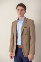 Saco color beige de poliéster, con solapa de muesca, cierre de dos botones, corte clásico y medio forro.