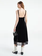 Vestido largo verde esmeralda de terciopelo con breteles finos regulables y escote en V. Detalles de encaje negro en escote y ruedo.
